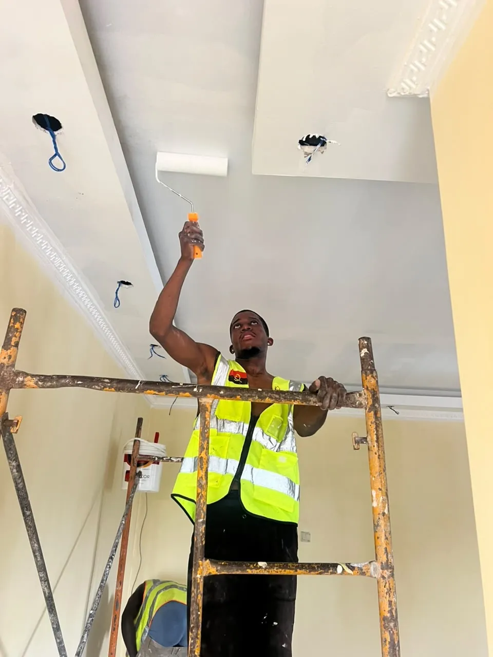 Técnico AngoInova a executar pintura de teto interior